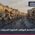 صورة تعبيرية لشارع تجاري في حماة مع مواقف سيارات
